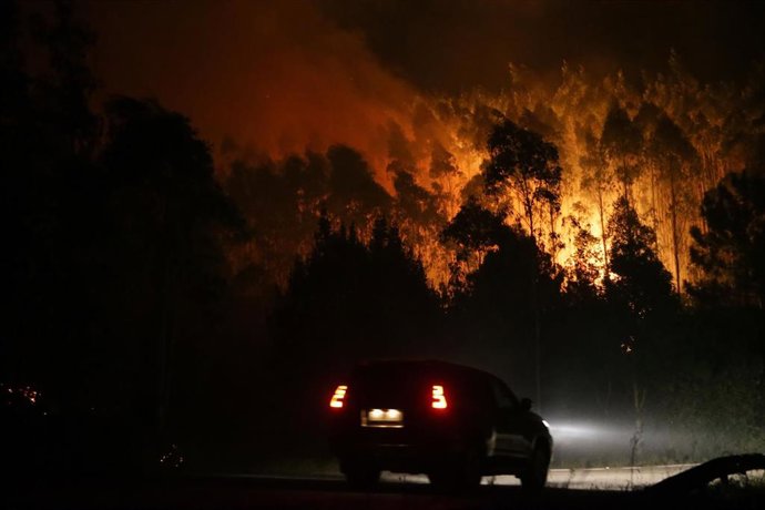 Un vehículo pasa por uno de los focos del incendio, a 12 de octubre de 2023, en Vidal, Trabada, Lugo, Galicia (España). La proximidad del incendio a núcleos de población ha obligado a declarar la denominada 'situación 2' en el ayuntamiento lugués de Tra