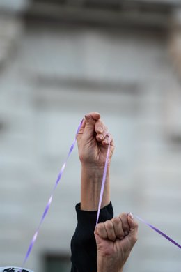 Varias personas sostienen un hilo morado durante una concentración contra la violencia machista convocada por el Foro de Madrid Contra la Violencia hacia las Mujeres, en la Puerta del Sol, a 25 de septiembre de 2023, en Madrid (España). 