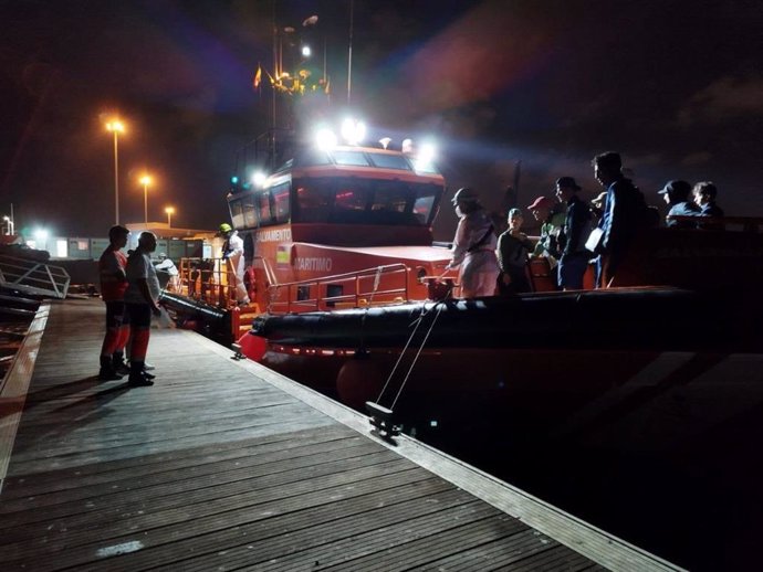Una embarcación de Salvamento Marítimo en el Puerto de Alicante y personal de Cruz Roja tras interceptar una patera.