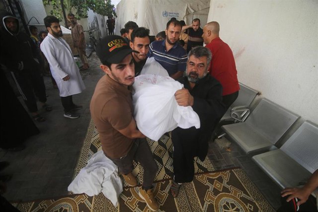 Ciudadanos de Gaza trasladan el cadáver de una víctima de los bobardeos israelíes.