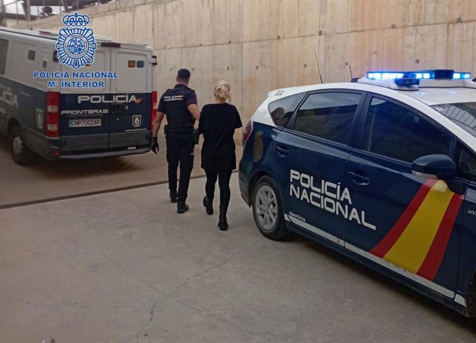 Un policía acompaña a una de las detenidas.