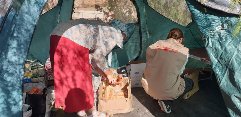 Una trabajadora de Cáritas junto a una mujer en una tienda de campaña en Marruecos.
