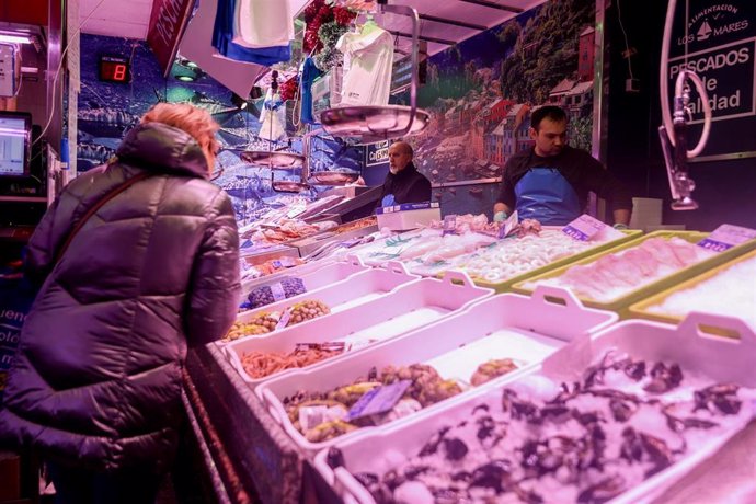 Archivo - Una mujer realiza sus últimas compras de pescado y marisco en la tienda de comestibles