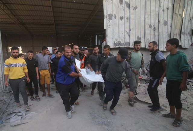 Un grupo de personas acarrea el cadáver de una víctima de los bombardeos israelíes.