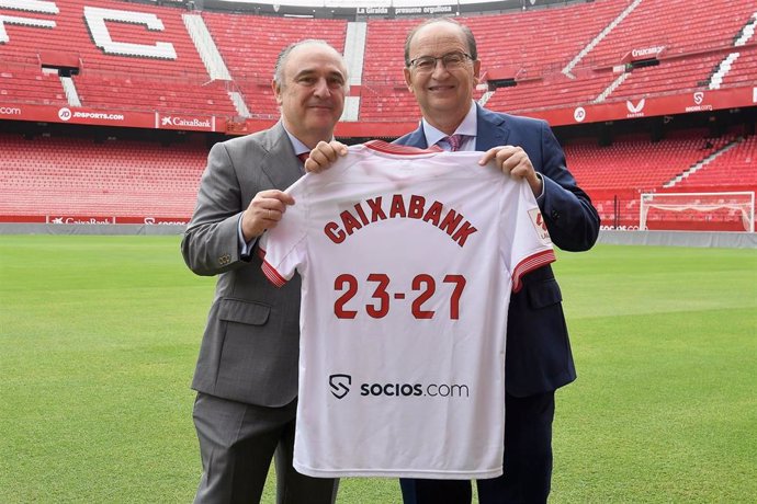 Juan Ignacio Zafra, director territorial de CaixaBank en Andalucía, y José Castro, presidente del Sevilla FC, con una camiseta sobre el césped del Pizjuán.