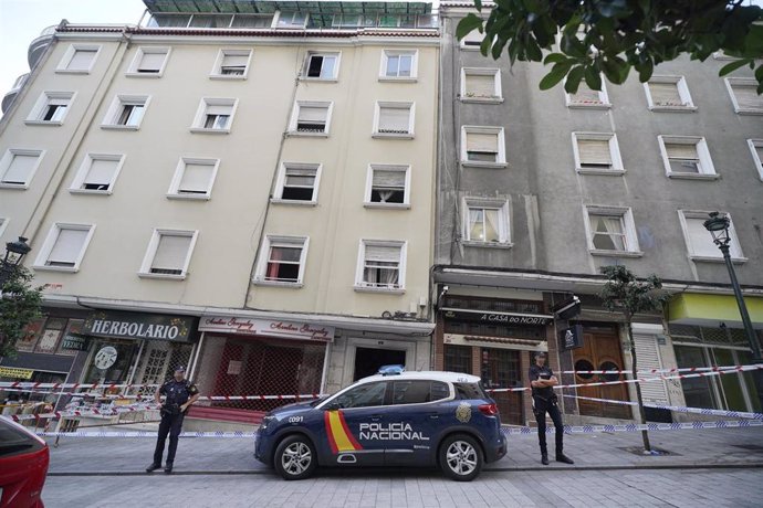 Un vehículo y dos agentes de Policía Nacional frente al edificio donde se ha producido un incendio en la calle Alfonso X el Sabio de Vigo, a 11 de octubre de 2023, en Vigo, Pontevedra, Galicia (España). Cuatro menores de edad han muerto y ocho personas 