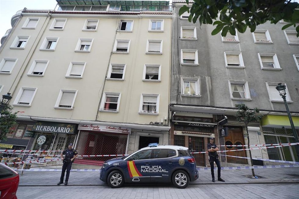 Un vehículo y dos agentes de Policía Nacional frente al edificio donde se ha producido un incendio en la calle Alfonso X el Sabio de Vigo, a 11 de octubre de 2023, en Vigo, Pontevedra, Galicia (España). Cuatro menores de edad han muerto y ocho personas