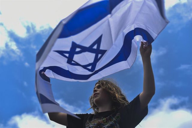 Manifestante portando una bandera de Israel durante una marcha en Brasil