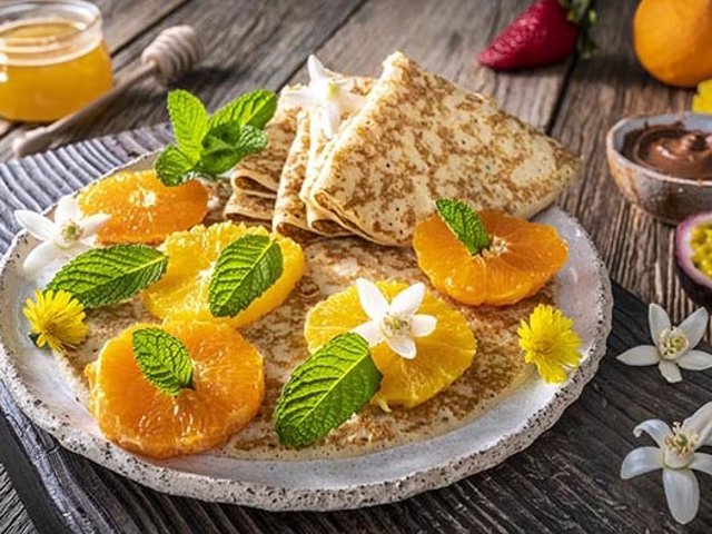 Archivo - Citrus Crepes arrangement with fruits, berries, cocoa cream and varied vegetarian food still life on rustic wood