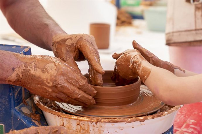 Archivo - Una niña hace cerámica en un torno alfarero de un puesto de cerámica artesanal, en una imagen de recurso.