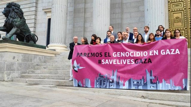 Varios diputados de diferentes grupos parlamentarios sostienen una pancarta que reza: "Paremos el genocidio en Gaza #savelivesgaza".