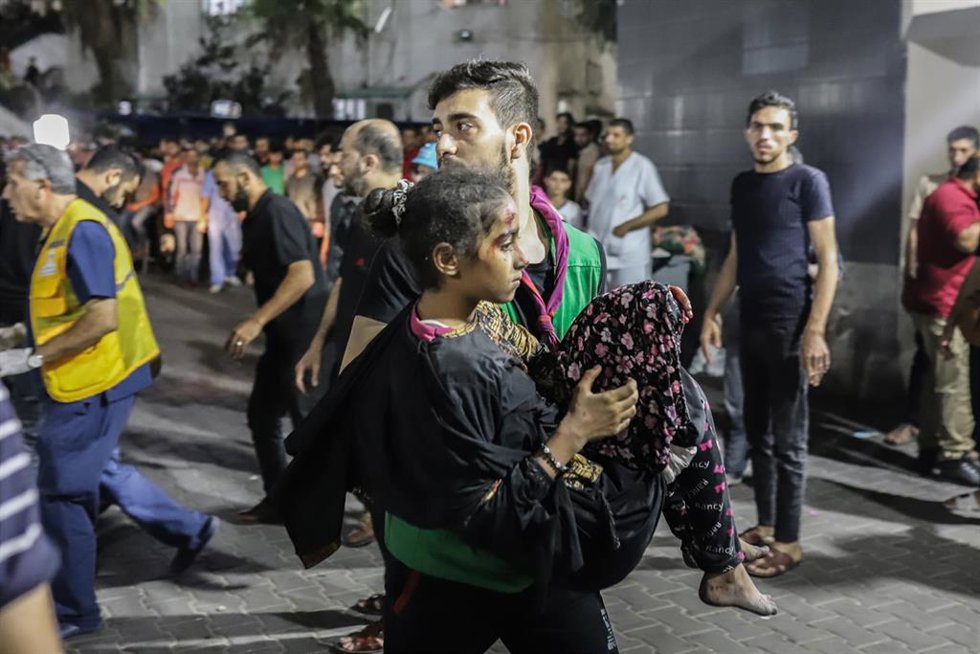 Un palestino lleva en brazos a una niña herida tras el bombardeo del hospital de Al Ahli, en el norte de la Franja de Gaza