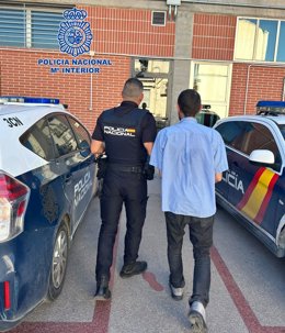 Imagen de uno de los detenidos, custodiado por la Policía Nacional