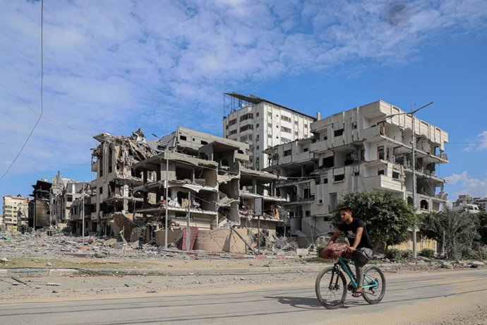 GAZA CITY, Oct. 18, 2023  -- A man rides a bike near buildings destroyed in Israeli airstrikes in Gaza City, on Oct. 17, 2023. Since the bloody conflict between Hamas and Israel began on Oct. 7, a total of 2,808 Palestinians have been killed and 10,850 