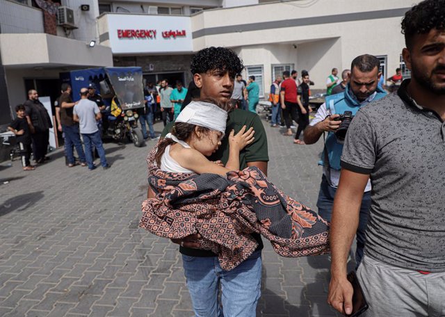 Un palestí trasllada un nen ferit després de l'atac a l'hospital