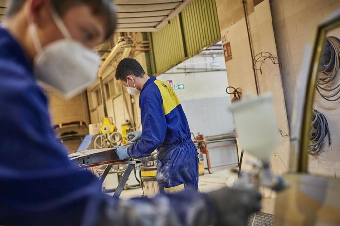 Archivo - Varias personas trabajando en mecánica.