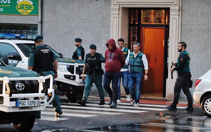La Guardia Civil y el detenido salen de la vivienda que ha sido registrada, a 17 de octubre de 2023, en A Gándara, Narón, A Coruña, Galicia (España). Efectivos de la Guardia Civil de A Coruña se han desplazado hasta el domicilio del detenido por el crim