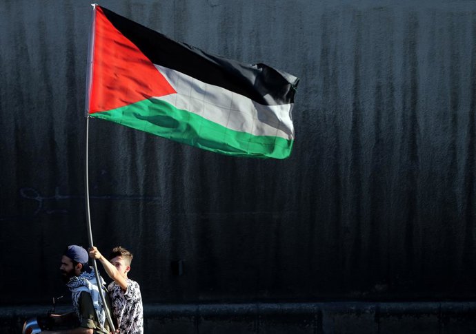 Archivo - Imagen de archivo de un libanés sosteniendo una banderae de Palestina en señal de apoyo.
