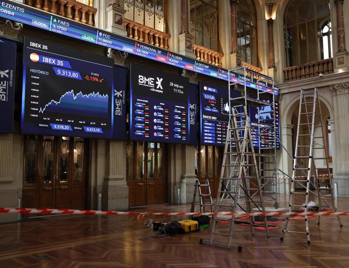 Varias escaleras frente a dos paneles del IBex 35, en el Palacio de la Bolsa, a 28 de septiembre de 2023, en Madrid (España). 