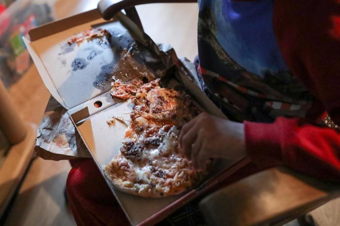 Archivo - Un niño come pizza 