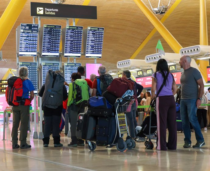 Archivo - Varias personas con maletas en el Aeropuerto Adolfo Suárez-Madrid Barajas.