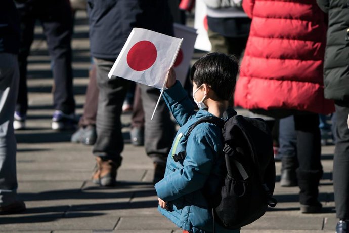 Archivo - 02 January 2023, Japan, Tokyo: A boy holds a Japanese national flag during the New Year's appearance by the Japanese royal family at the Imperial Palace. Photo: -/ZUMA Press Wire/POOL/dpa