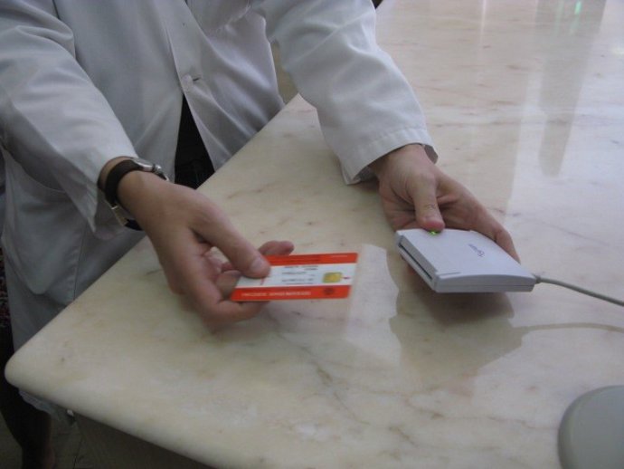 Archivo - Una persona introduce una tarjeta sanitaria para una receta electrónica.