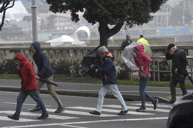 Varias personas se protegen de la lluvia y el viento con paraguas, a 20 de octubre de 2023, en A Coruña, Galicia (España). 