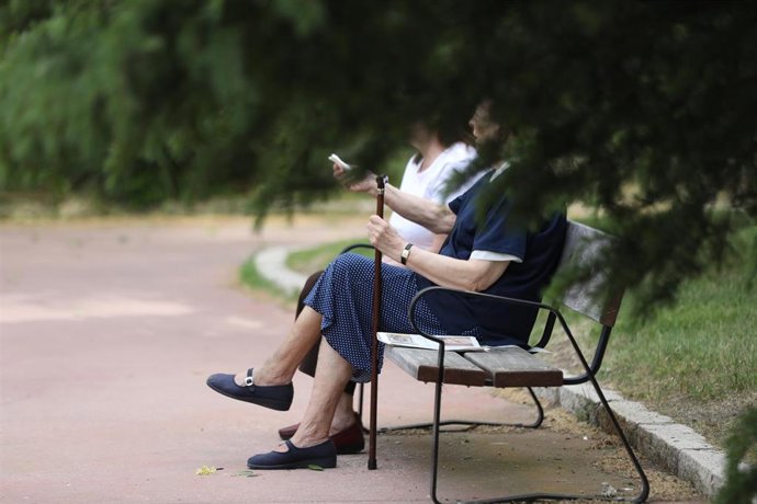 Archivo - Dos mujeres de edad avanzada disfrutan sentadas en un banco de la capital durante su franja horaria permitida en la desescalada por la crisis del Covid-19 donde aquellos mayores de 70 años pueden salir a la vía pública de 10.00 a 12.00 horas y