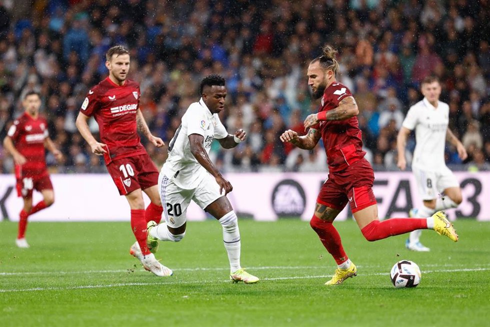 Archivo - El brasileño Vinícius Júnior (Real Madrid) encará al sevillista Nemanja Gudelj, en un partido en el Santiago Bernabéu. 