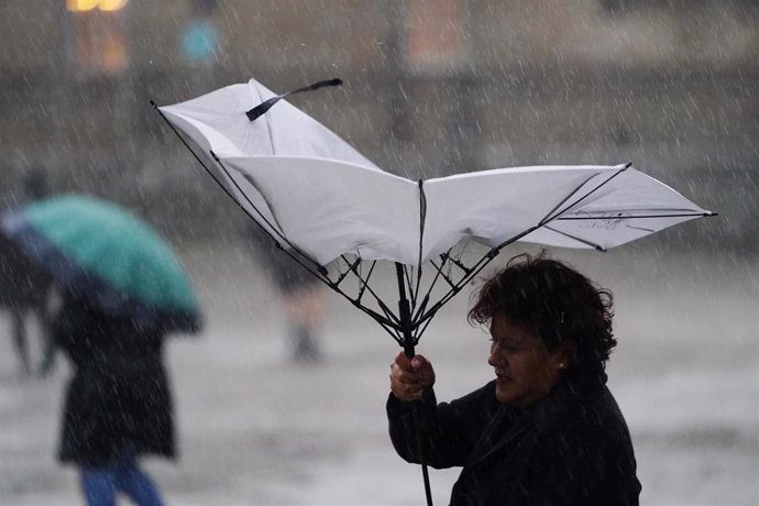 Una mujer sujeta un paraguas durante el paso de la borrasca Aline, a 19 de octubre de 2023, en Santiago de Compostela