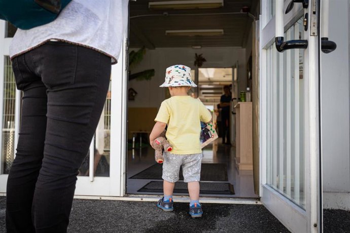 Archivo - Un niño pequeño entra por la puerta hacia el interior de las instalaciones de una guardería