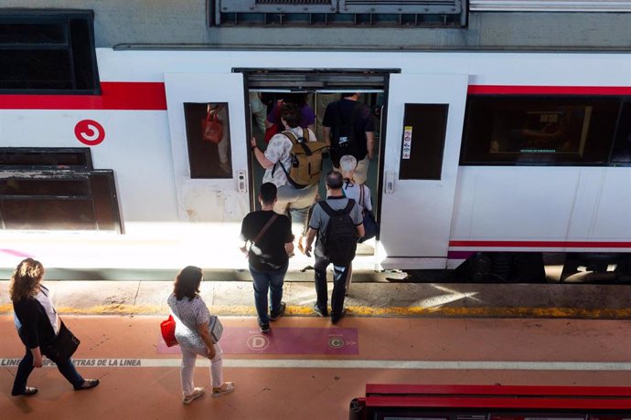 Varias personas a su entrada en un vagón de tren en la estación de Puerta de Atocha-Almudena Grandes, con motivo del inicio del puente del Pilar, a 11 de octubre de 2023, en Madrid (España). 