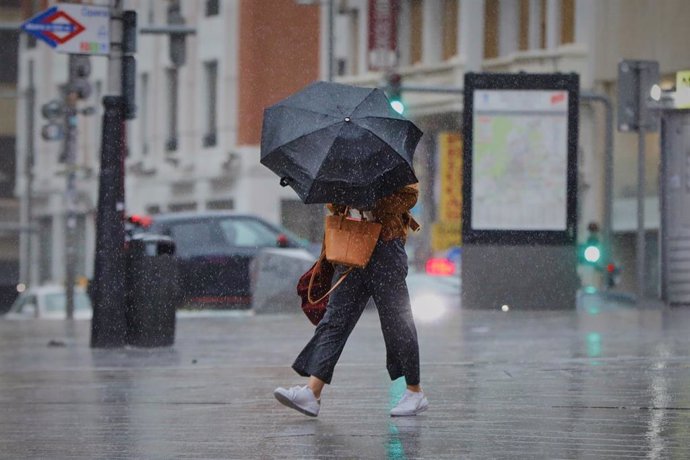 Archivo - Una persona camina por el centro de la capital en una jornada marcada por las lluvias y la bajada de temperaturas, en Madrid, (España).