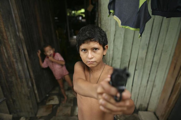 Archivo - Un niño sujetando una pistola en la ciudad colombiana de Barrancabermeja