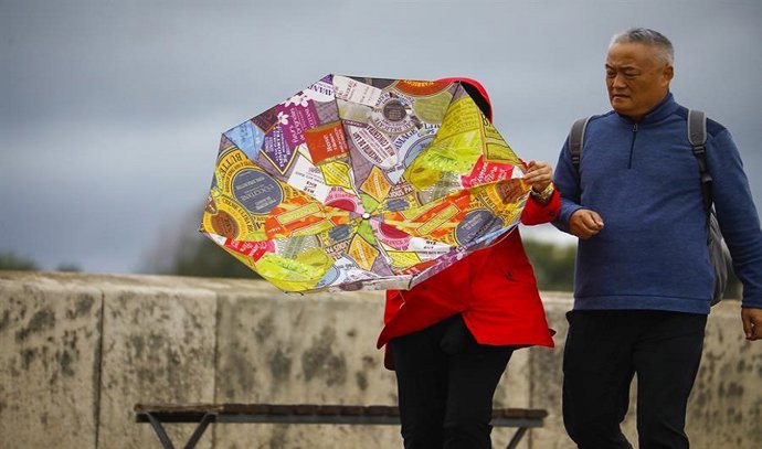Dos personas intentan protegerse del fuerte viento en una imagen de archivo.