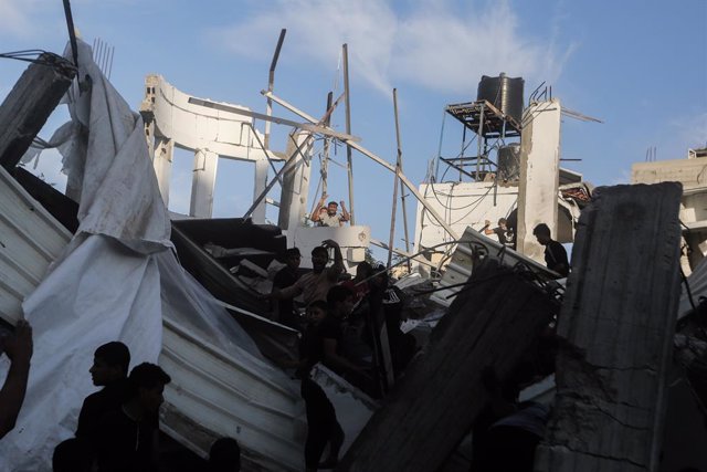 21 October 2023, Palestinian Territories, Khan Yunis: Palestinians inspect the rubble after an Israeli raid near a school belonging to the United Nations Relief and Works Agency for Palestine Refugees (UNRWA) in Khan Yunis, southern Gaza Strip. Photo: Moh