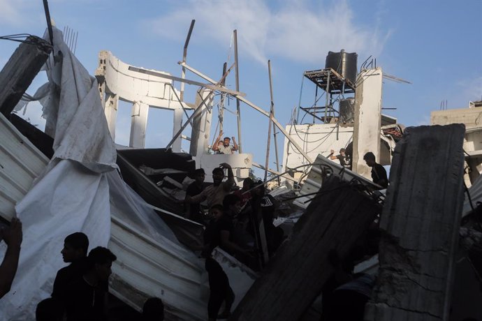 21 October 2023, Palestinian Territories, Khan Yunis: Palestinians inspect the rubble after an Israeli raid near a school belonging to the United Nations Relief and Works Agency for Palestine Refugees (UNRWA) in Khan Yunis, southern Gaza Strip. Photo: M