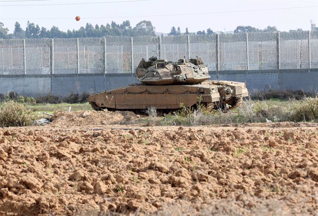 Archivo - December 7, 2022, Gaza, Palestine: An Israeli Merkava battle tank is stationed near Israeli excavators and bulldozers demolishing the remains of the Karni commercial crossing near the border of Gaza, as Israel decided to extend a security barrie