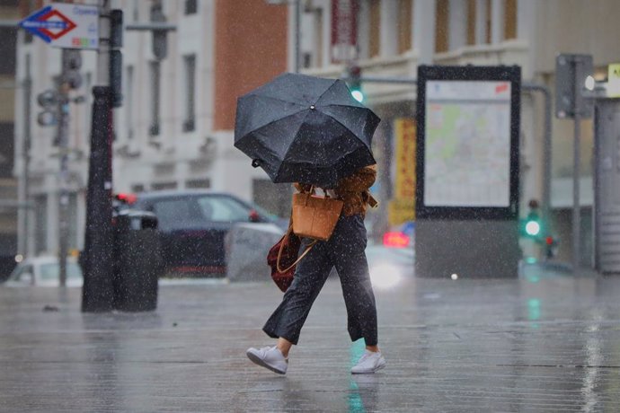 Archivo - Una persona camina por el centro de la capital en una jornada marcada por las lluvias y la bajada de temperaturas, en Madrid, (España), a 2 de octubre de 2020. Esto se debe a la llegada de la borrasca atlántica Alex que se profundiza desde aye