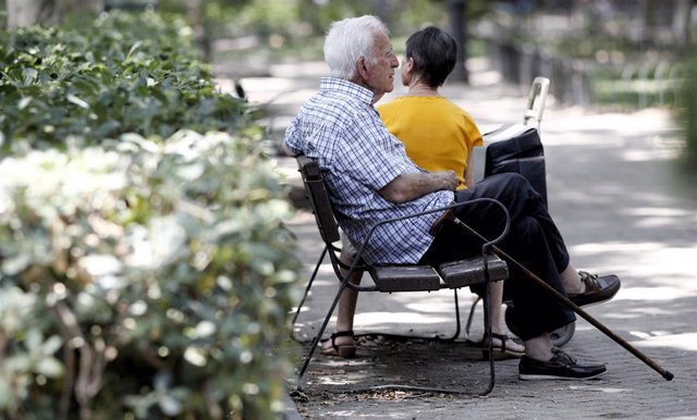 Archivo - Un pensionista descansa en un banco de un parque de Madrid