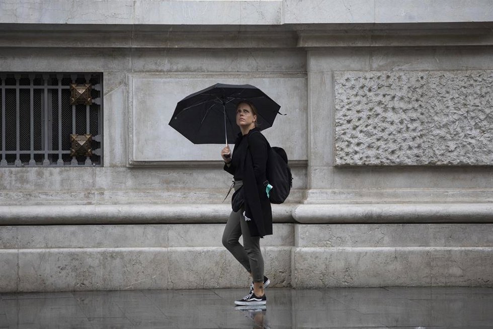 Archivo - Una mujer se protege de la lluvia bajo su paraguas. Imagen de archivo.