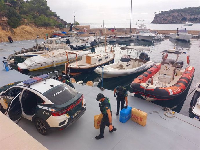 Agentes de la Guardia Civil trasladan algunos de los fardos incautados.