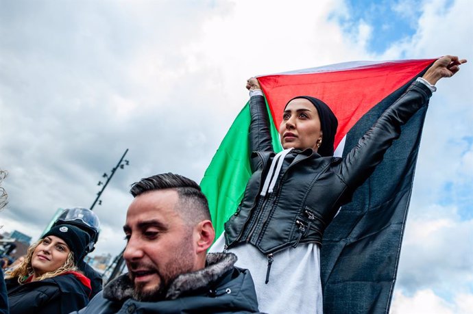 October 22, 2023, Rotterdam, South Holland, Netherlands: A Palestinian woman stands on a motorbike while holding a Palestinian flag during the demonstration. Palestinians and their supporters keep protesting to condemn the government of Israel and expre