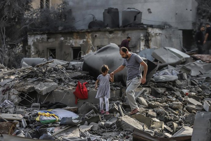 23 October 2023, Palestinian Territories, Gaza City: A Palestinian and a child inspect the destruction caused by an Israeli strike. Photo: Mohammad Abu Elsebah/dpa