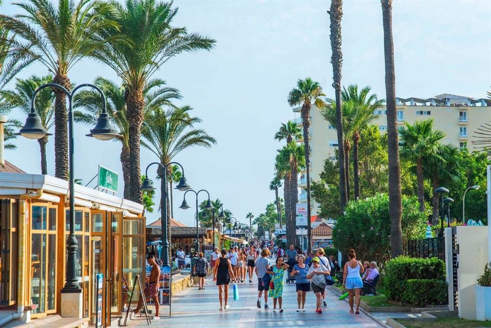 Turistas caminan por el paseo marítimo de Torremolinos.