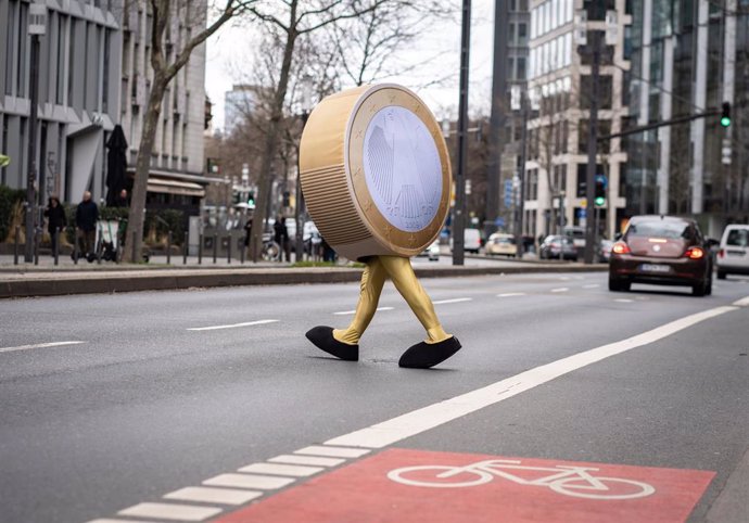 Archivo - 21 February 2022, Hessen, Frankfurt_Main: A performer dressed as a "Eurolino" in the form of a one-euro coin on legs crosses a street in front of the temporary headquarters of the German Federal Bank (Deutsche Bundesbank) in Frankfurt during f