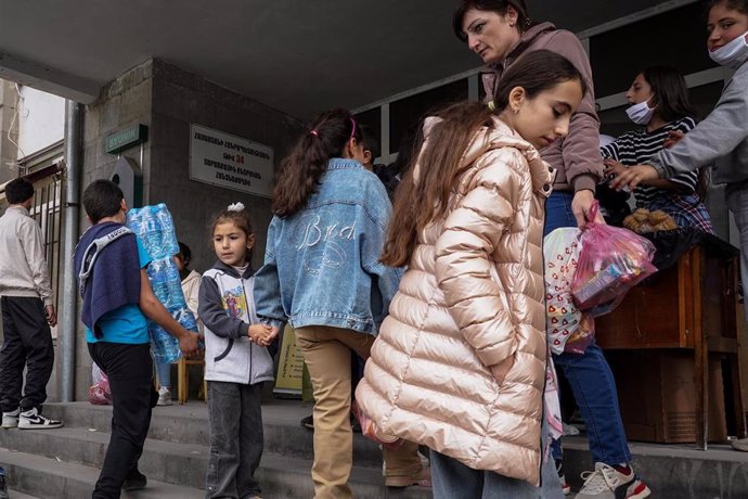 Un grupo de refugiados huidos de la región de Nagorno Karabaj espera para recibir ayuda humanitaria en la ciudad de Goris, en Armenia