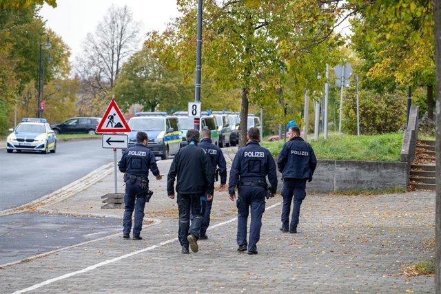 24 October 2023, Bavaria, Hollfeld: Police officers walk in front of the compound of the comprehensive school in Hollfeld. Bomb threats were again received at several schools in Bavaria on Tuesday. Photo: Pia Bayer/dpa
