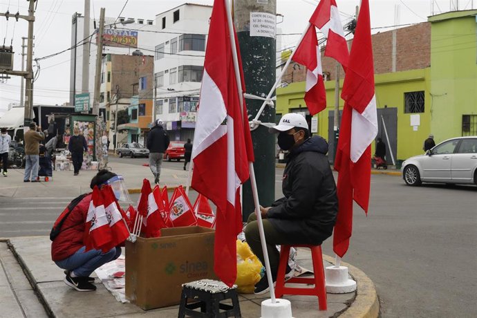 Archivo - Banderas peruanas en un puesto de un mercado de Lima.
